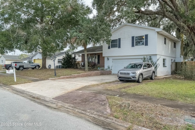 split level home with a garage and a front lawn