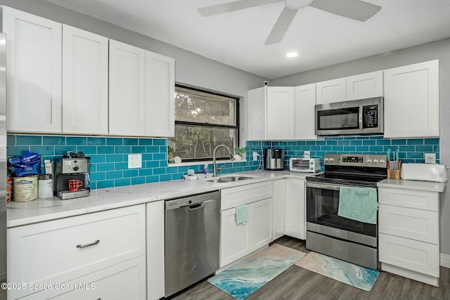 kitchen with stainless steel appliances, dark hardwood / wood-style flooring, white cabinetry, and sink