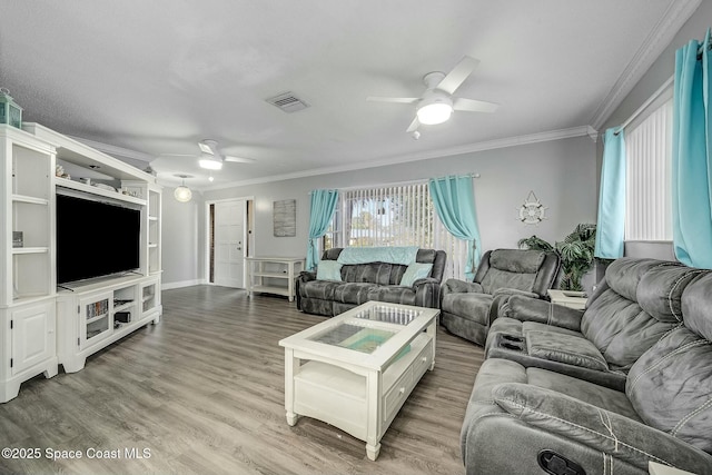 living room featuring ceiling fan, wood-type flooring, and crown molding