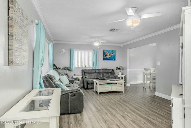 living room featuring ceiling fan, crown molding, and light hardwood / wood-style flooring