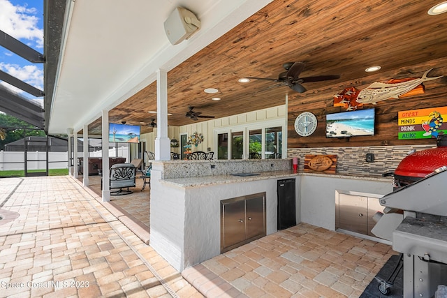 view of patio with glass enclosure and ceiling fan