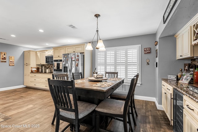 dining space featuring light hardwood / wood-style floors and beverage cooler