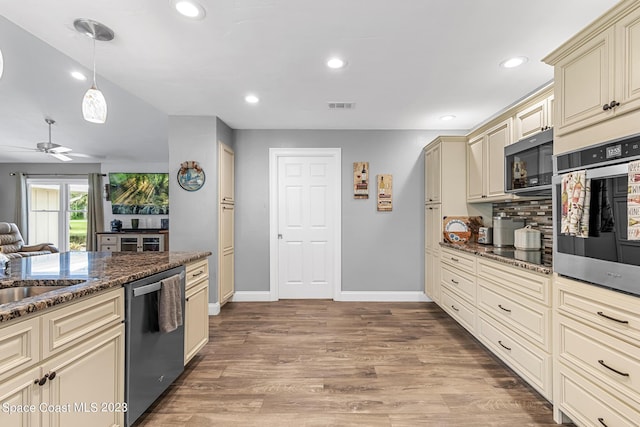 kitchen with ceiling fan, light hardwood / wood-style flooring, cream cabinets, dark stone counters, and appliances with stainless steel finishes