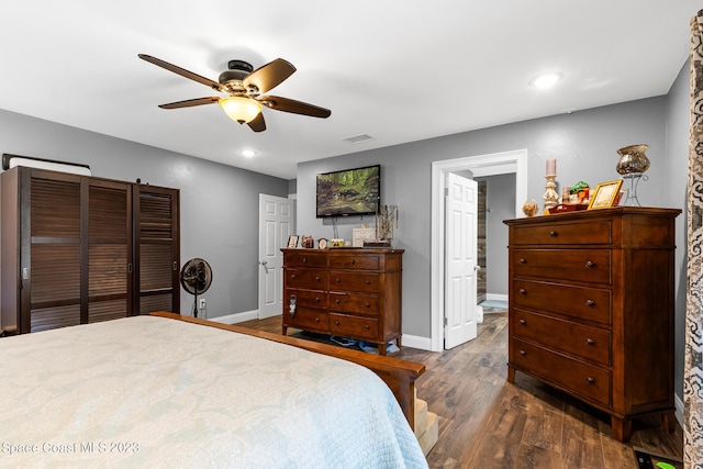 bedroom featuring dark hardwood / wood-style floors, ensuite bath, and ceiling fan