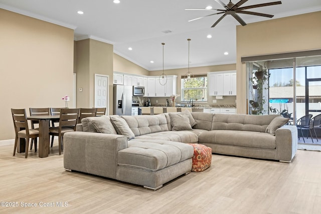 living room featuring light wood-type flooring, ceiling fan, crown molding, sink, and lofted ceiling