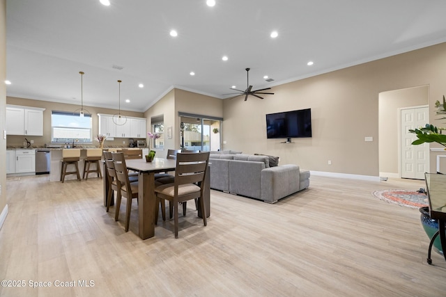 dining area featuring crown molding, plenty of natural light, ceiling fan, and light wood-type flooring