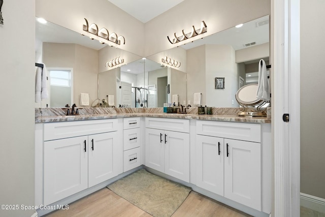 bathroom featuring wood-type flooring, vanity, and walk in shower