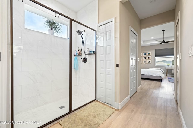 bathroom featuring a tile shower, hardwood / wood-style flooring, and ceiling fan