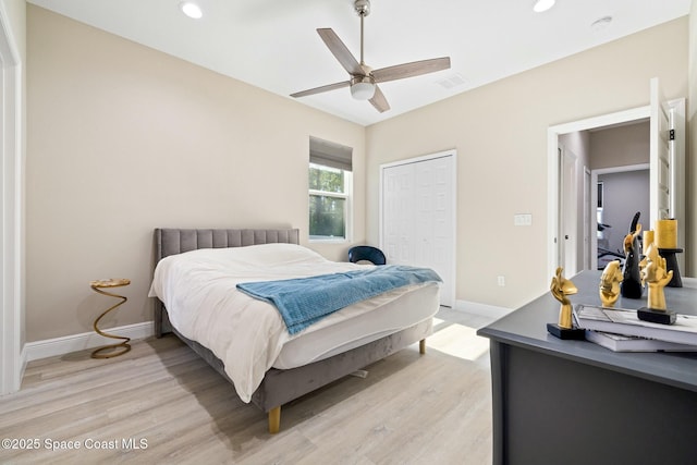 bedroom with ceiling fan, light wood-type flooring, and a closet