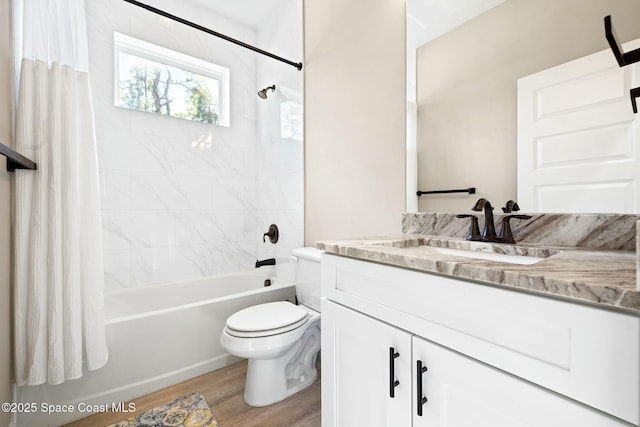 full bathroom with wood-type flooring, vanity, shower / tub combo, and toilet