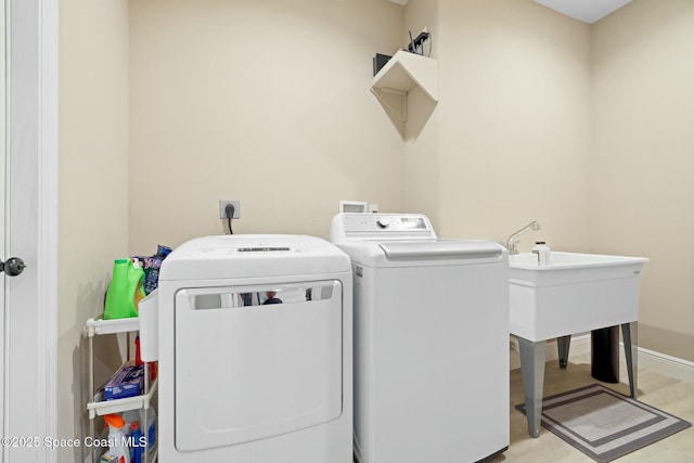 clothes washing area with independent washer and dryer and light hardwood / wood-style floors