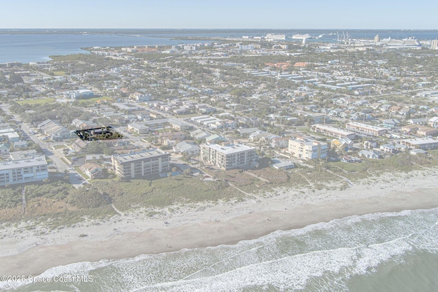 birds eye view of property with a water view and a beach view