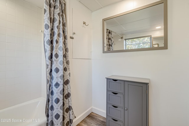 bathroom featuring wood-type flooring and shower / bathtub combination with curtain