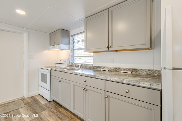 kitchen with gray cabinetry, sink, white appliances, and light wood-type flooring