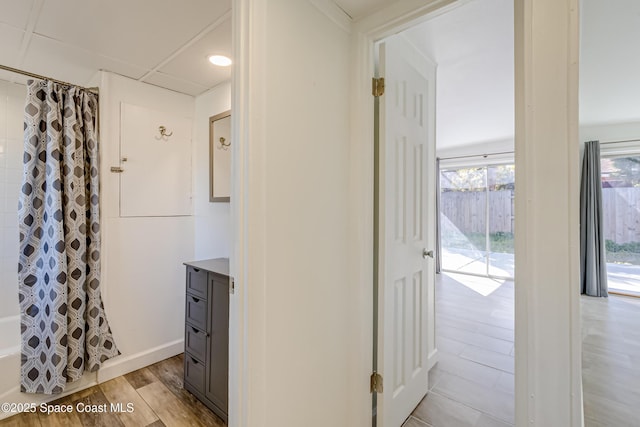 hallway featuring a paneled ceiling and light hardwood / wood-style flooring