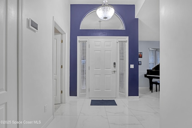 foyer entrance with a high ceiling and a notable chandelier