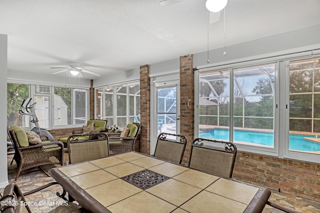 unfurnished sunroom featuring ceiling fan and a wealth of natural light