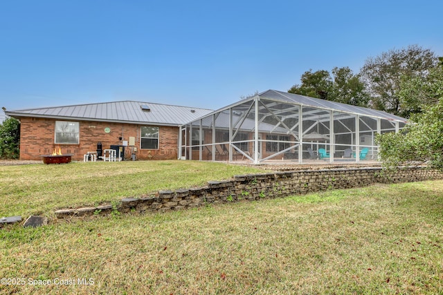 back of property with a yard and glass enclosure