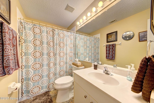 bathroom with tile patterned flooring, vanity, toilet, and a textured ceiling