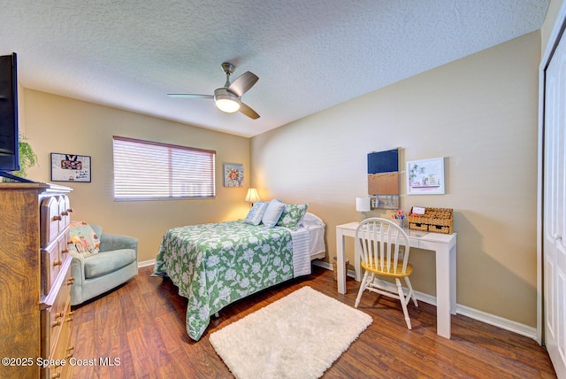 bedroom with a closet, a textured ceiling, dark hardwood / wood-style floors, and ceiling fan