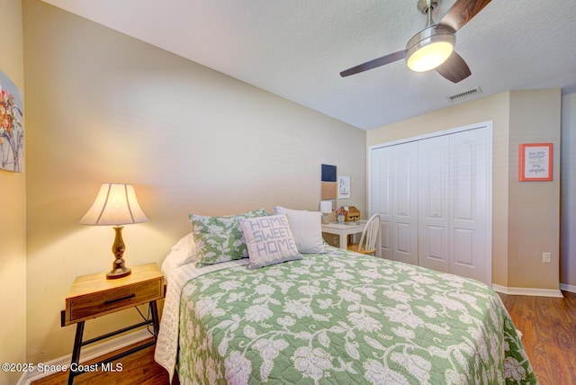 bedroom with ceiling fan, dark hardwood / wood-style floors, and a closet