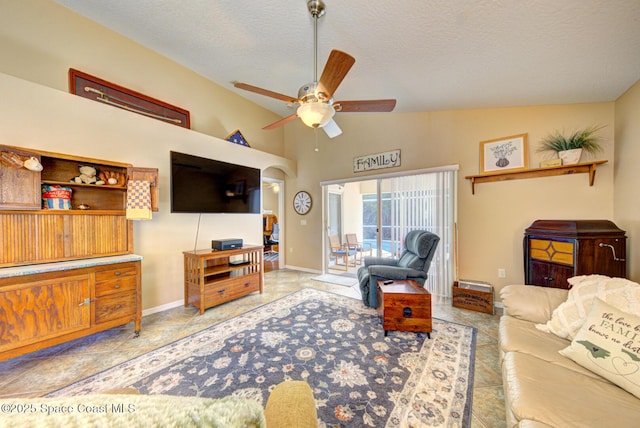 living room featuring a textured ceiling, ceiling fan, and lofted ceiling