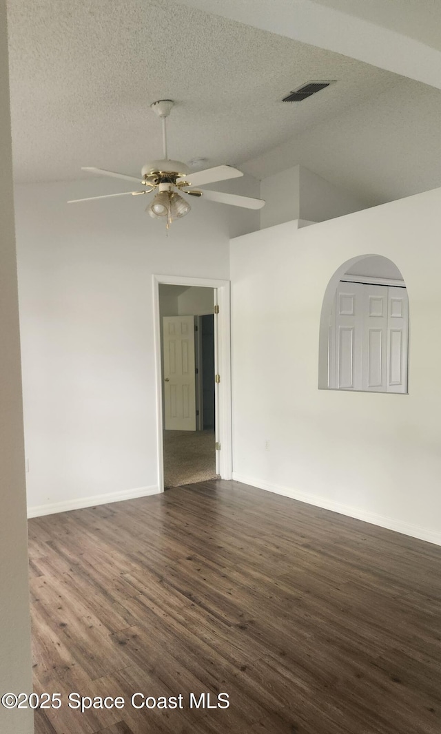 spare room featuring ceiling fan, a textured ceiling, and dark wood-type flooring