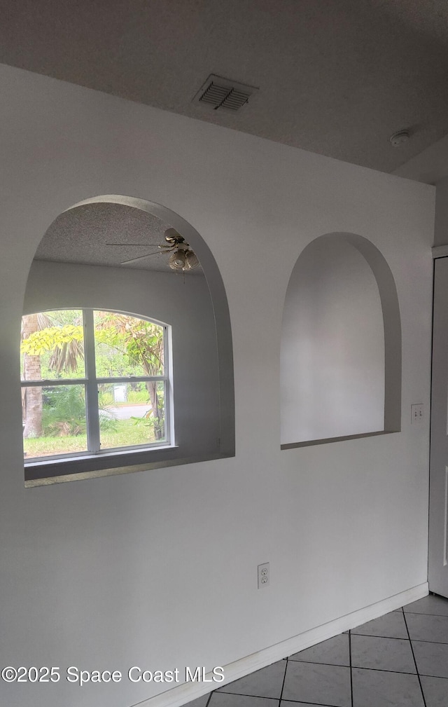 empty room with tile patterned floors and ceiling fan