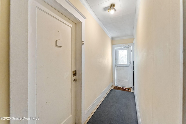 hall with dark carpet and crown molding