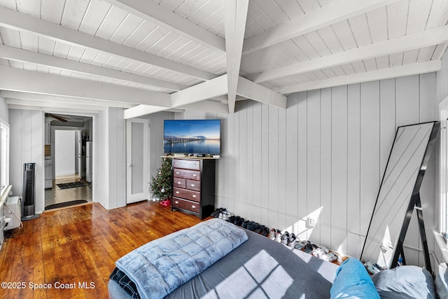 bedroom featuring dark hardwood / wood-style floors, beam ceiling, and wooden walls