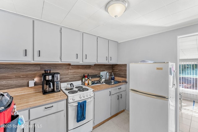 kitchen featuring white appliances, tasteful backsplash, and sink