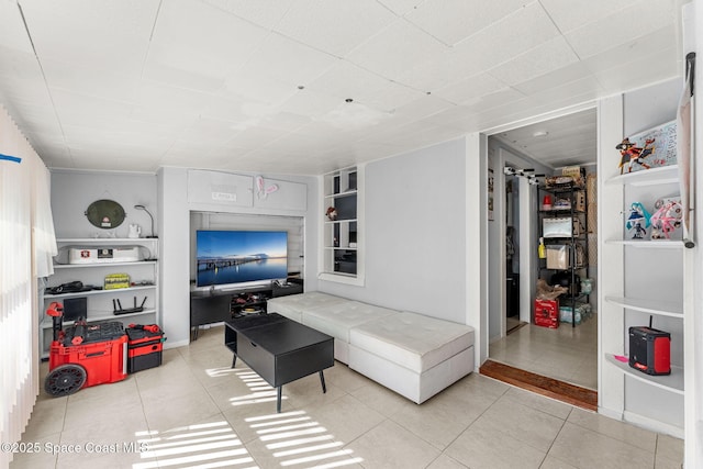 living room with built in shelves and light tile patterned floors