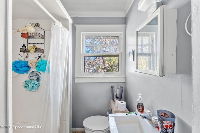 bathroom with curtained shower, crown molding, sink, and toilet