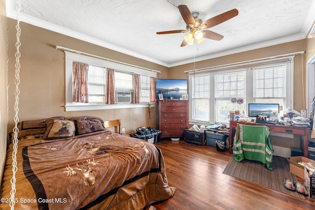 bedroom with hardwood / wood-style floors, ceiling fan, crown molding, and a textured ceiling