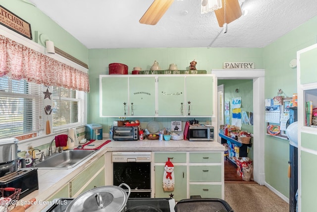 kitchen featuring carpet, sink, ceiling fan, a textured ceiling, and black dishwasher