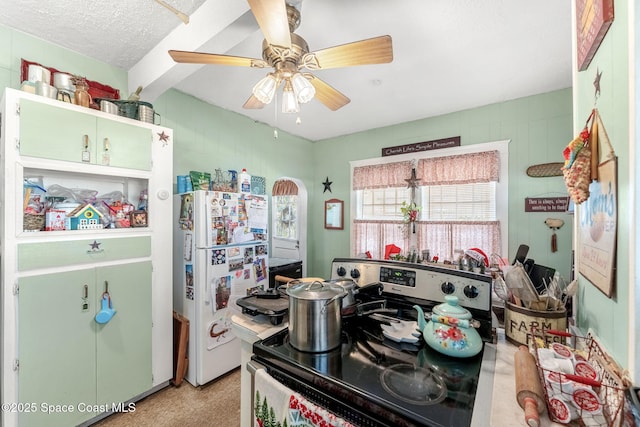 kitchen featuring a textured ceiling, white fridge, stainless steel electric range oven, and ceiling fan