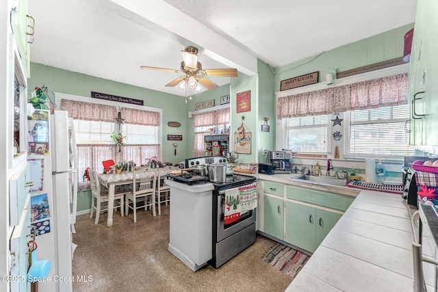 kitchen with kitchen peninsula, ceiling fan, sink, tile countertops, and stainless steel electric range oven