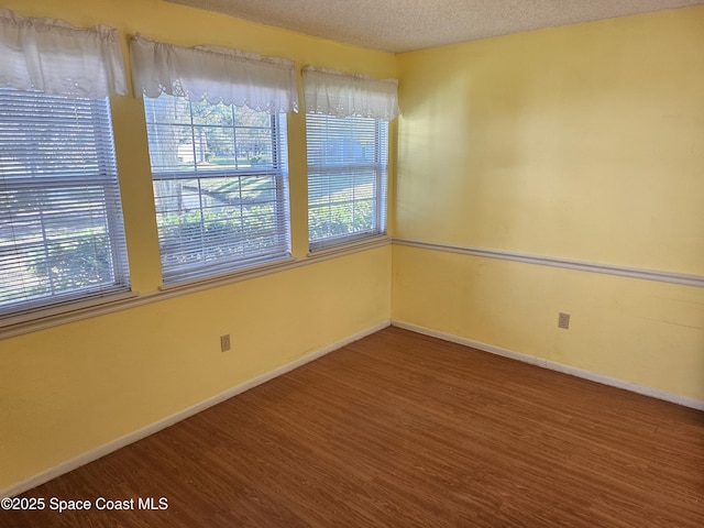 spare room with hardwood / wood-style floors and a textured ceiling