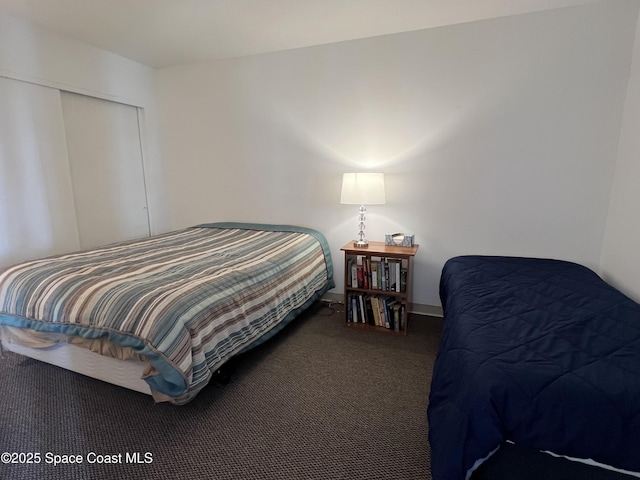 bedroom featuring dark carpet and a closet