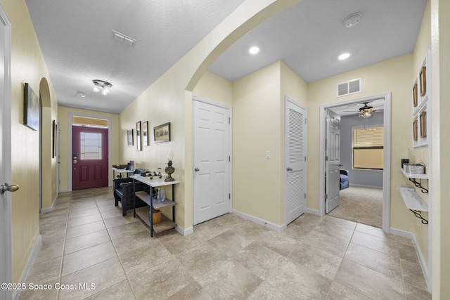 entryway featuring ceiling fan and a textured ceiling