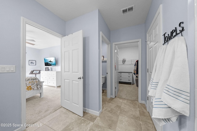 bathroom with ceiling fan, toilet, and a textured ceiling