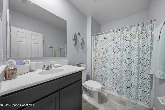 bathroom featuring a shower with shower curtain, a textured ceiling, vanity, and toilet