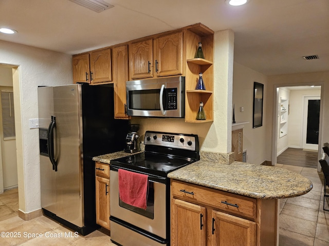 kitchen featuring light tile patterned floors, light stone counters, kitchen peninsula, and appliances with stainless steel finishes