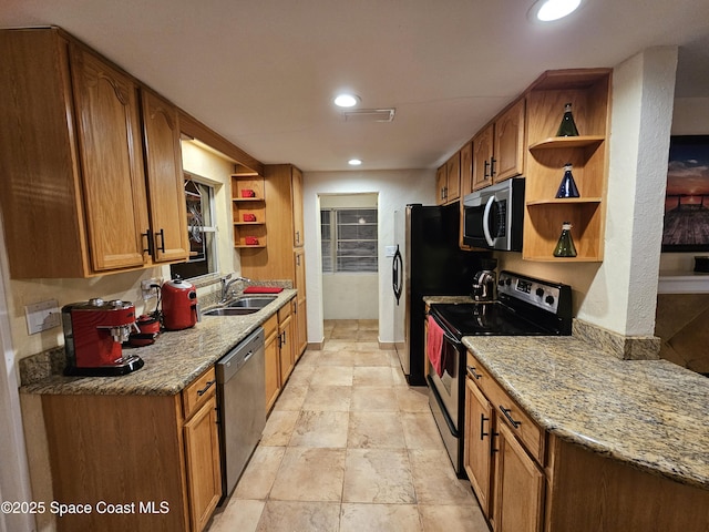 kitchen with sink, light stone countertops, and stainless steel appliances