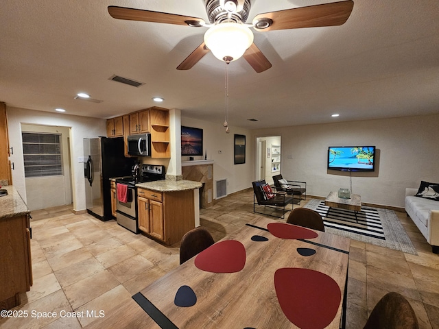 kitchen featuring light stone countertops, appliances with stainless steel finishes, and ceiling fan