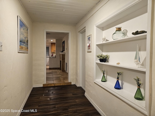 hall featuring dark hardwood / wood-style flooring, built in features, and wooden ceiling