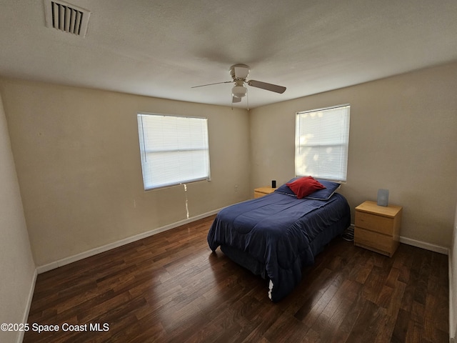 bedroom with multiple windows, dark hardwood / wood-style floors, and ceiling fan