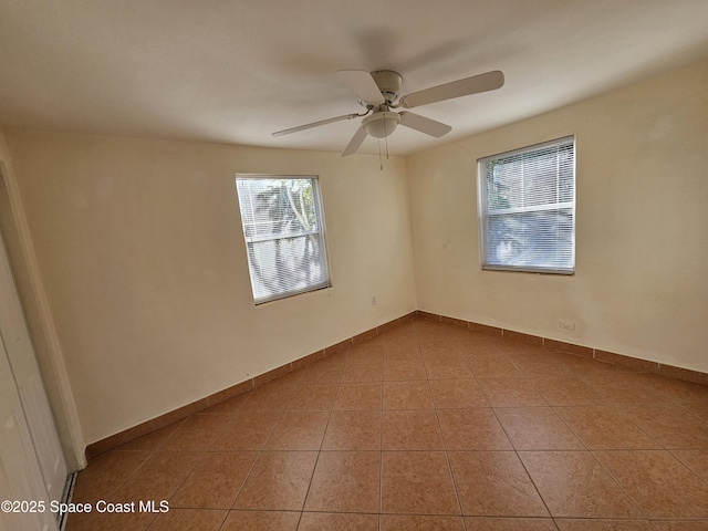 tiled spare room featuring ceiling fan