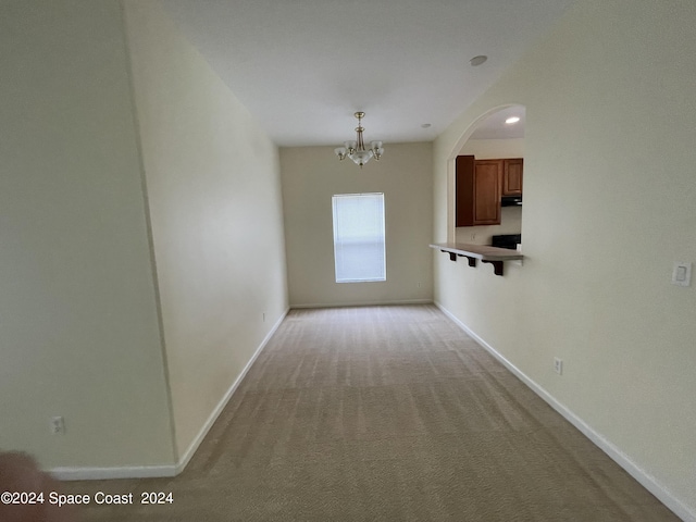 interior space featuring light carpet and a chandelier