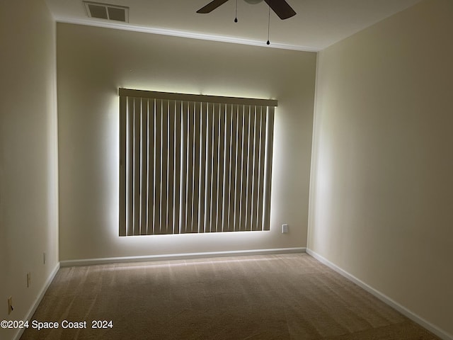 carpeted empty room featuring ceiling fan and ornamental molding